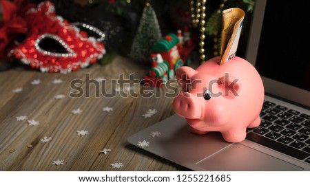 Pink piggy bank with banknote on a laptop. Closeup