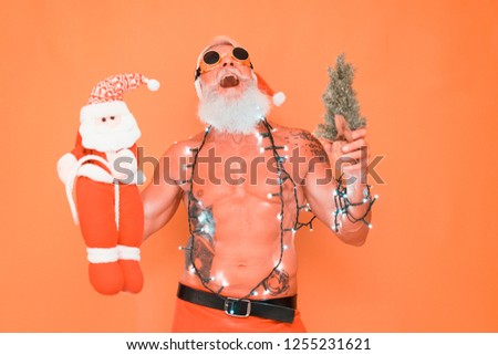 Fashion tattoo Santa Claus wearing vintage christmas lights - Fit senior man with winter holiday costume on coral background - Winter, trendy people, vacation concept - Focus on his face