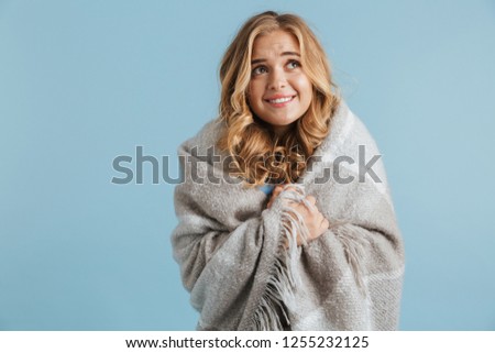 Image of gorgeous woman 20s wrapped in blanket looking at camera isolated over blue background