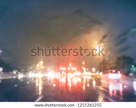 Vintage tone blurred abstract stopped car at traffic light intersection and rear lights reflection on the rainy asphalt road. Defocused cityscape and transportation background in America