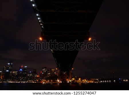 Colorful light reflection at Sydney Harbour Bridge, viewed from Milsons Point in North Sydney Australia. The Iconic Landscape of illuminated Sydney city and Harbour Bridge at night with cloudy sky.
