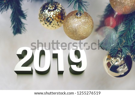 Shiny gold christmas balls on white with pine tree and 3d 2019 text.