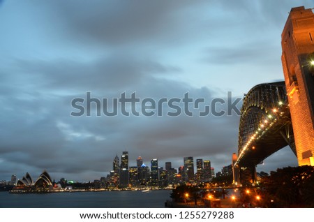 Colorful light reflection at Sydney Harbour Bridge, viewed from Milsons Point, Australia. The Iconic Landscape of illuminated Sydney city Bridge at night with cloudy sky.