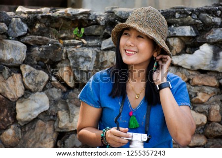 Travelers thai woman travel and sitting relax on trunk bench in garden of Pa Tueng Hot Spring at Mae Chan in Chiang Rai, Thailand