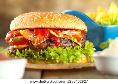 Close-up of home made burgers with french fries on old wooden table closeup.