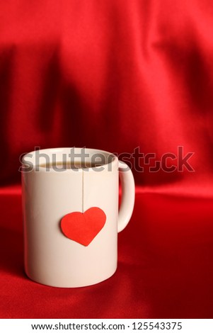 Close-up of white cup of tea and a label in the form of heart