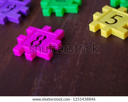 colorful puzzle Jigsaw plastic number on the wooden table. Concept of education and math learning