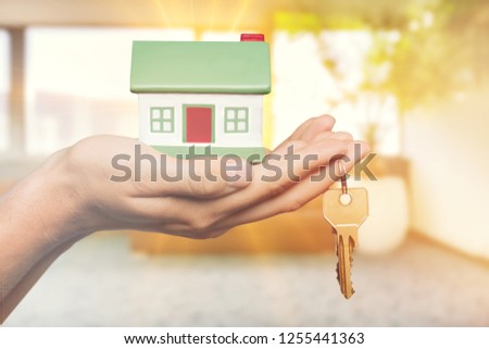 Home key in house keychain on woman/ man/ human hand support offering security protection awareness concept: Insurance agent in white shirt holding happy residential key lock/ unlock insure habitat
