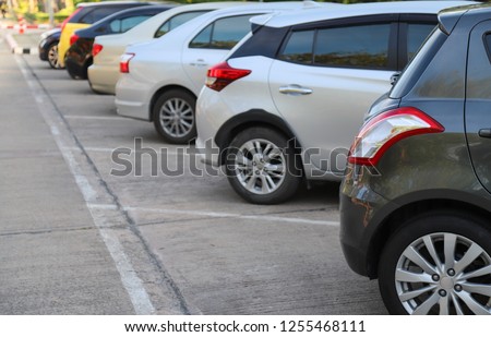 Closeup of rear side of black car parking in parking area with natural background in the evening of sunny day. Royalty-Free Stock Photo #1255468111