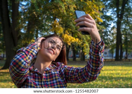 Selfie time. Beautiful young girl taking a selfie at the park.