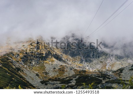 View of a lift or a cable car from Skalnate pleso to Lomnicky stit, High Tatras, Slovakia. Mountain alpine like landscape with high peak or summit in the clouds.
