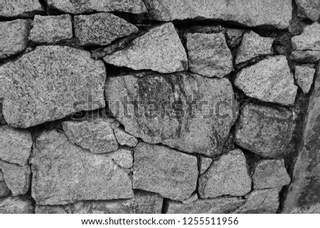 Black & white background of old stone wall texture photo. Monochrome shot & image of decorative random size stone with realistic detailed pattern, copy space. Wall made from real stone in nature. 
