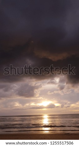 sunset at sea with black thunder rays in the sky, horizon of the sea and sky