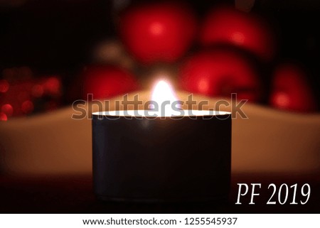 Happy new year 2019 white text on picture with burning candle and fruits in blurr background.