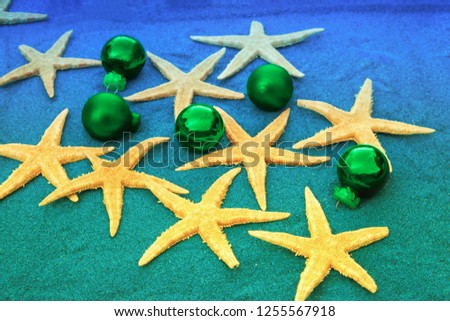 Christmas ornaments and starfish on the beach sand.