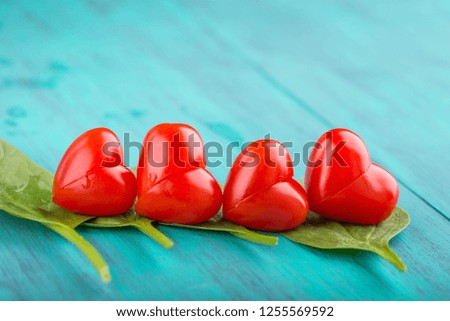 cherry tomatoes heart shape on turquoise background