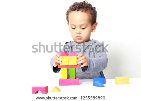 little boy testing his creativity by building towers with toy building blocks stock photo