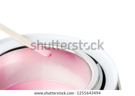 Close-up of wax heater with hot pink wax and a wooden spatula