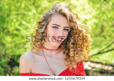 Perfect curly hair. Blonde curly long hair. Perfect woman smiling on spring sunny background. Beauty and perfect health hair. Beauty model with perfect clean skin. Good hair