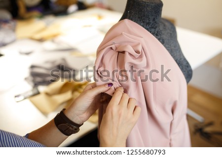 female dressmaker attach fabric to mannequin with needles. creating dress design. Tailor industry concept. Royalty-Free Stock Photo #1255680793