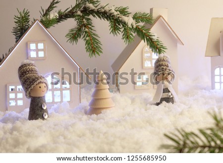 Christmas decor for children. Christmas fairy tale on a snowy background. Cardboard houses with Christmas garland. Selective focus layout.
