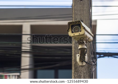 CCTV security video camera protect on the electricity with building as background.