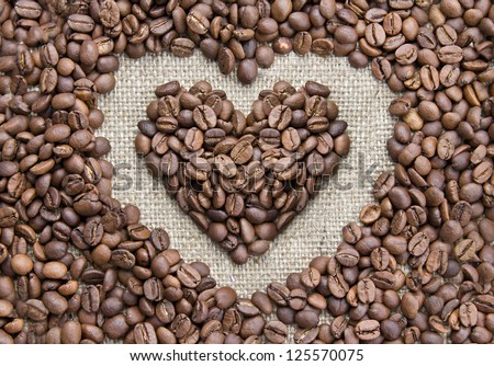 Coffee beans, grain heart on background of sacking, bagging. Valentine's Day or Wedding, love, black, frame. Heart shaped Coffee Beans