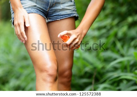 Mosquito repellent. Bug spray anti insects for zika virus in rain forest jungle. Woman spraying insect repellent putting on skin outdoor in nature using spray bottle. Royalty-Free Stock Photo #125572388