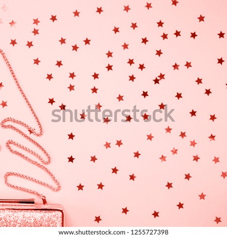 Festive evening golden clutch with star sprinkles on pink. Holiday and celebration background. Luxury accessories and party concept. Square. Living coral theme - color of the year 2019