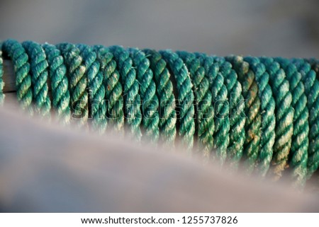 Turquoise and green fishing robes wrapped around a wooden trunk. 