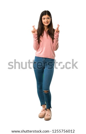 A full-length shot of a Teenager girl with pink shirt with fingers crossing and wishing the best