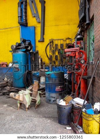 Unclean and messy corner inside an auto repair workshop somewere in the city of Bogota, Colombia.