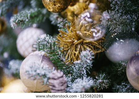 Bright festive decorations celebrating Christmas and New Year. Christmas toys, glass balls and garlands on the Christmas branches. Soft focus and beautiful bokeh.