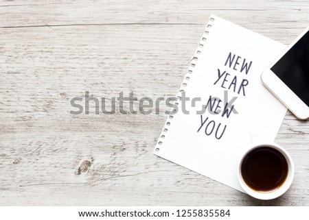 New Year New You text on notepad, smart phone and coffee cup. Business motivation, inspiration concept. Top view with copy space.
