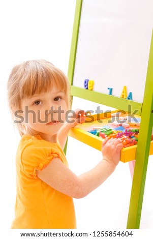 Happy baby girl beautiful painting on the easel on a white background