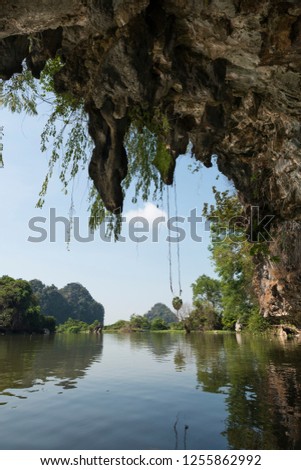 Vertical picture from inside of huge cave. Beuatiful view of trees and river close to Sadan Cave in Hpa-An, Myanmar