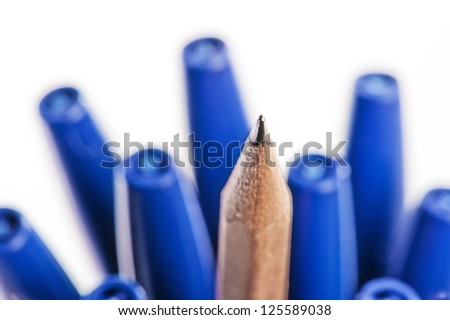 Sharpened pencil between pens in caps.
