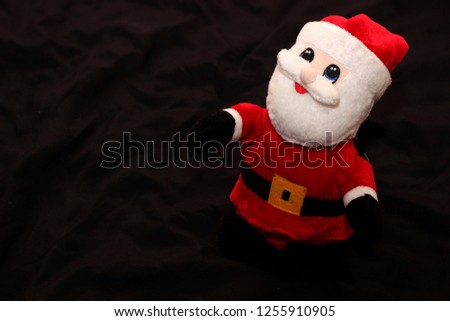 Little Santa claus doll on black background