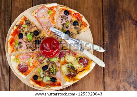 Six slices of pizza with different toppings on wooden board. Studio Photo