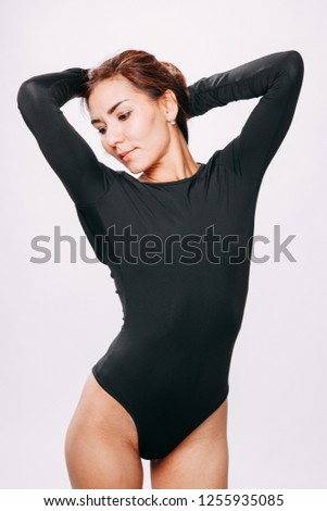Beautiful girl in swimsuit posing against  grey white  background