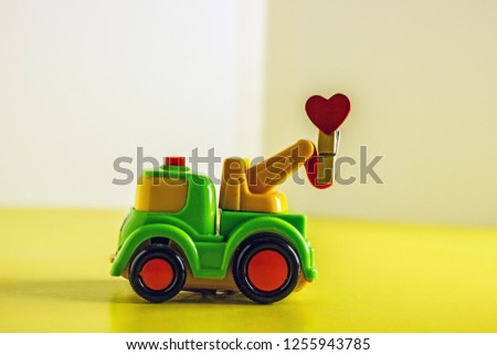Toy crane hoisting close-up on yellow background, Cartoon toy machine, toy machine