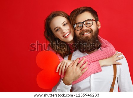 valentine's day concept. happy young couple with heart, flowers, gift on red background
