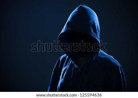Scary evil woman with hood in darkness
