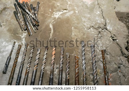 Drills on concrete of different diameter and degree of novelty for a perforator lie on a concrete plate in cracks.