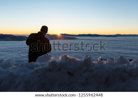 Photographer taking pictures of foggy inversion over Washoe valley in the winter at sunrise