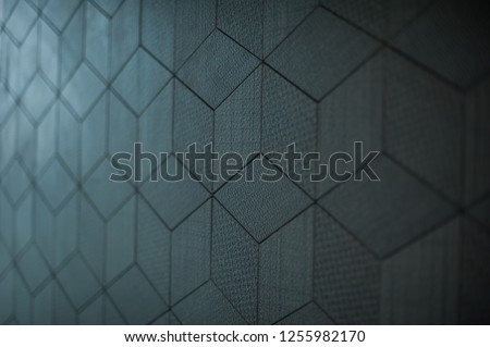 Dark grey colour triangle geometrical design wall tiles close up, selective focus and background blur.