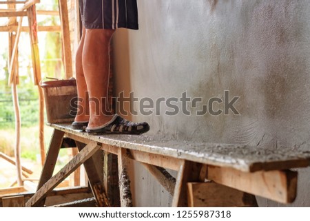 Showing legs of a man standing on the Wood bench while working in a construction site