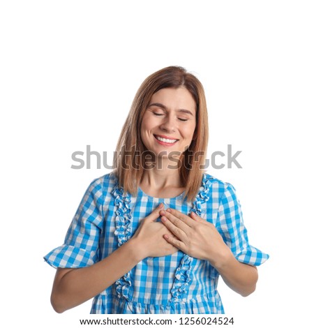 Woman holding hands near heart on white background