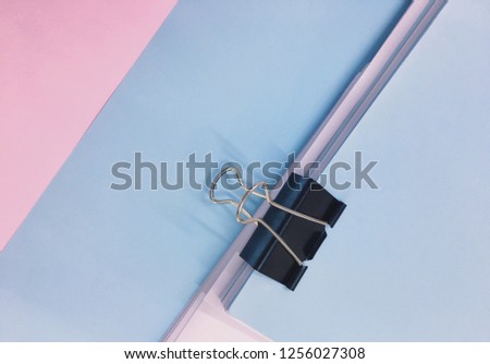 Black metallic paper clip with blue, pink and white paper for document concept, pile of paper and documents