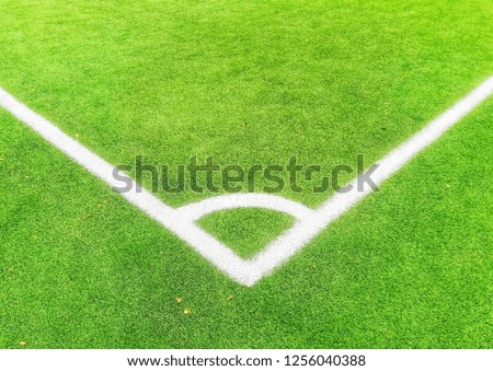 Green synthetic grass sports field texture with white line envelop shape. Beautiful pattern of fresh green grass for football sport, football field, soccer field, team sport concept .